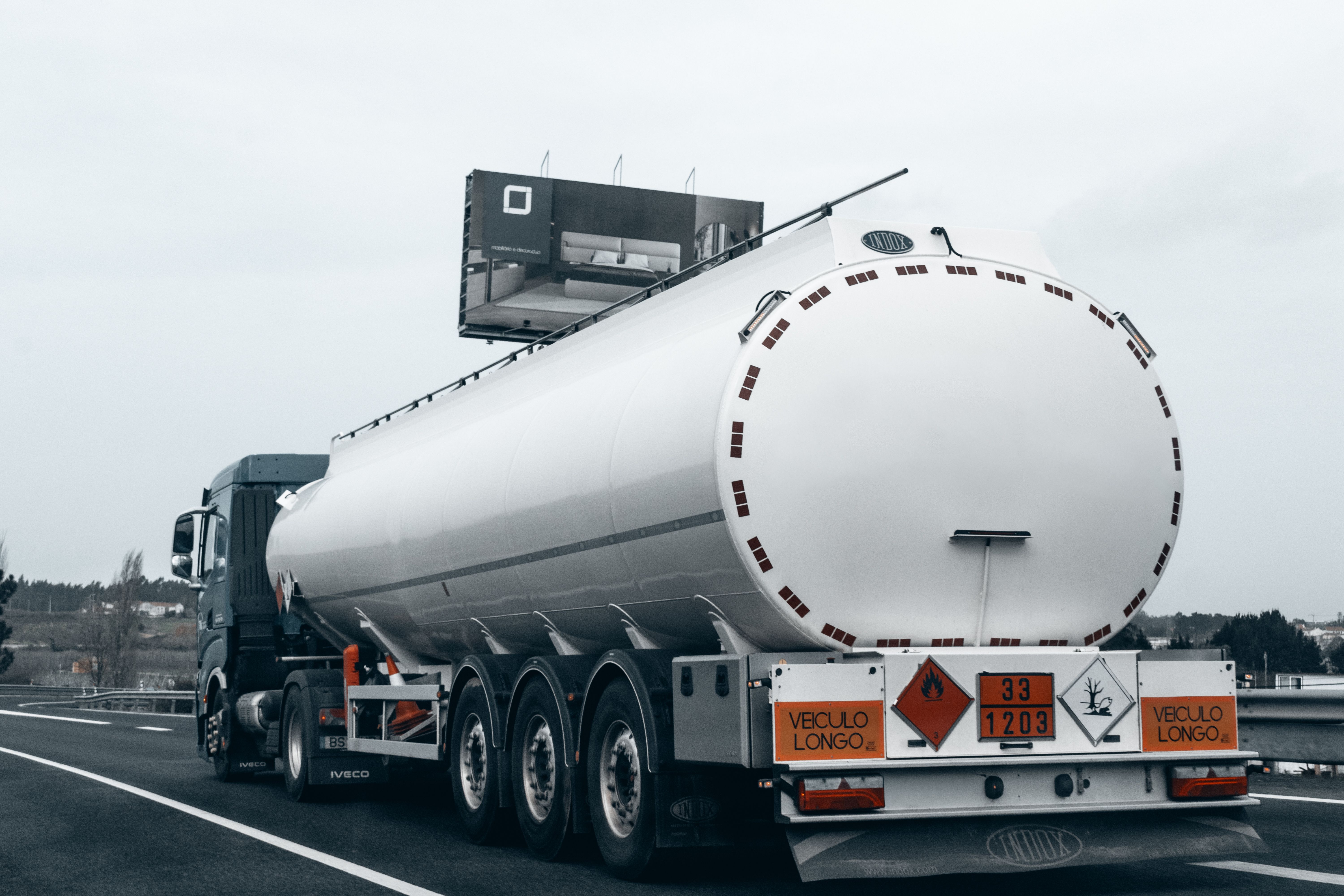 Large tanker truck transporting fuel on a highway, emphasizing the connection between fuel costs and logistics.