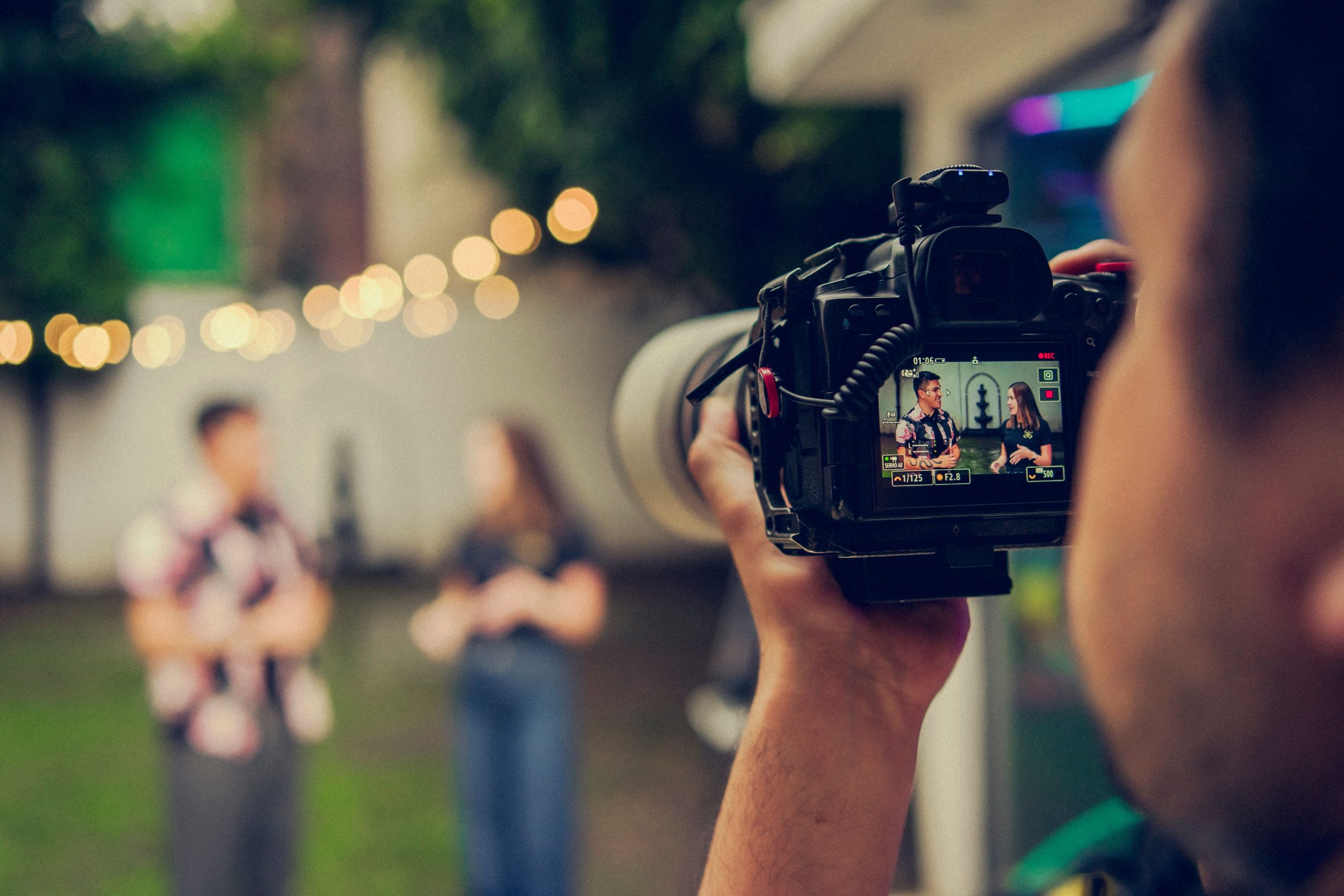 Outdoor interview being filmed in a lush garden with soft background bokeh.