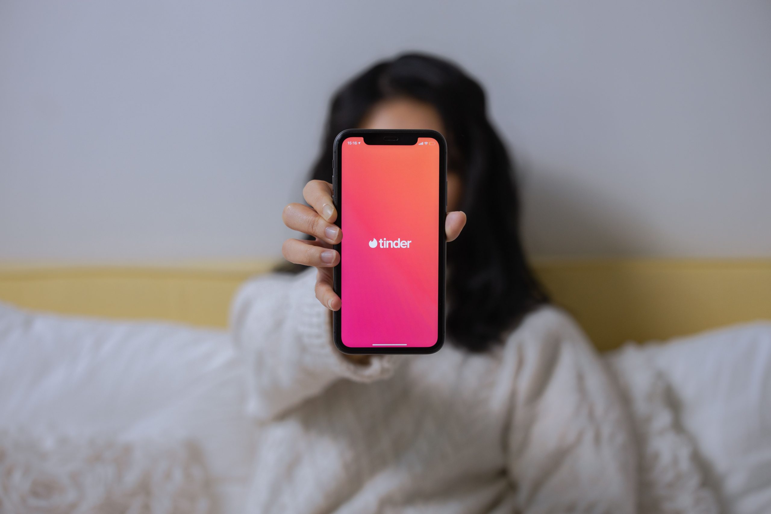 Young woman browsing a dating app on her smartphone indoors