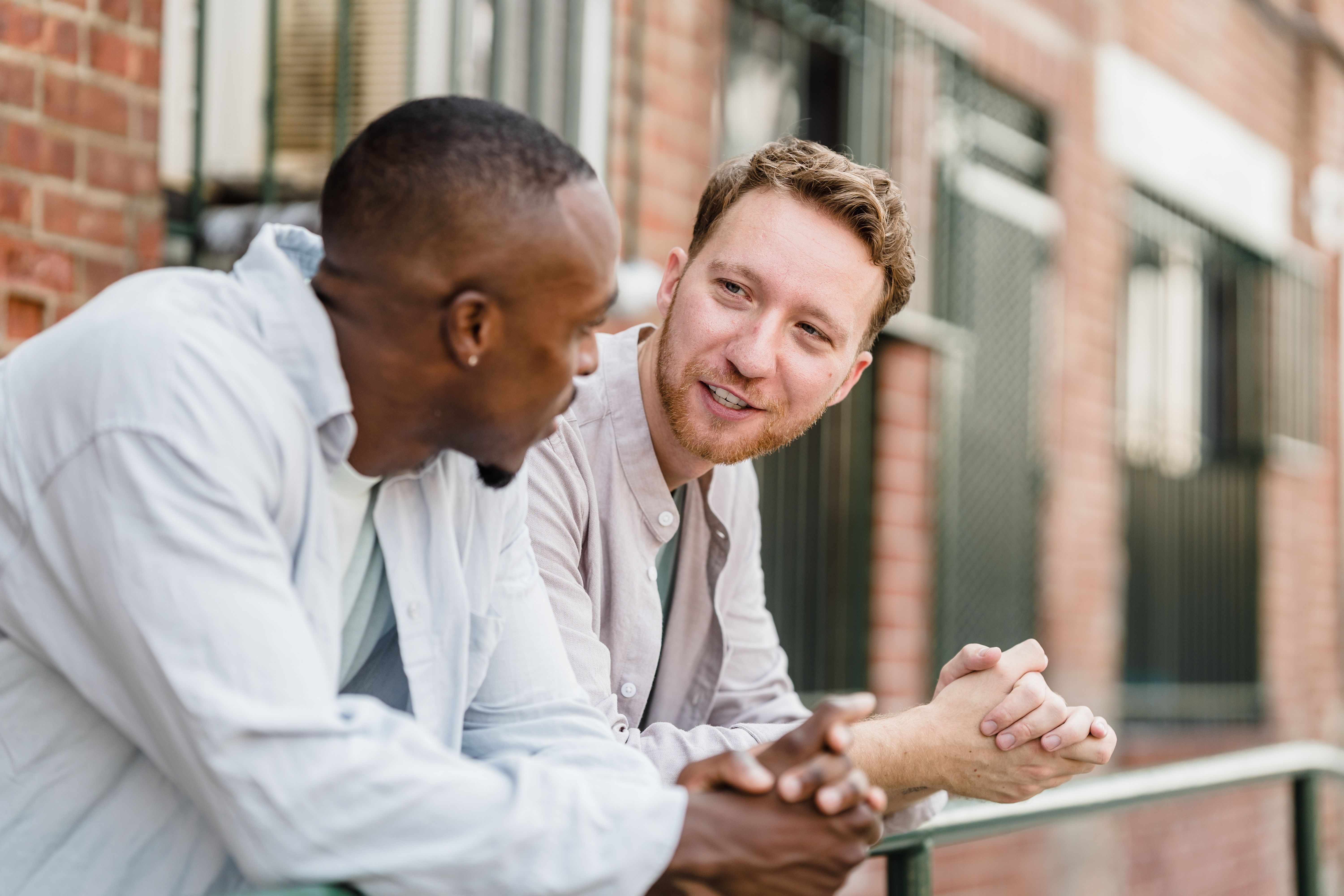 Two young men having a lively conversation outdoors