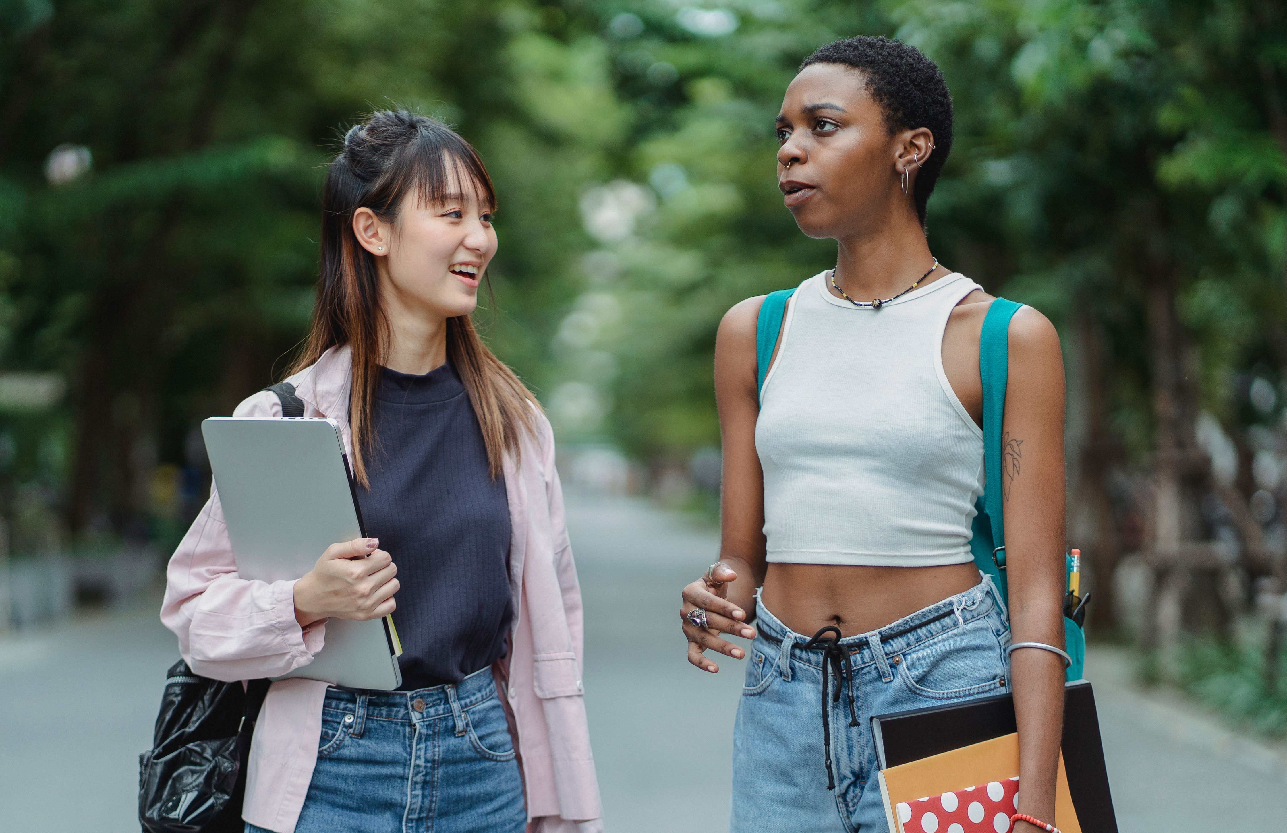 Multiracial young women walking together and talking in a park